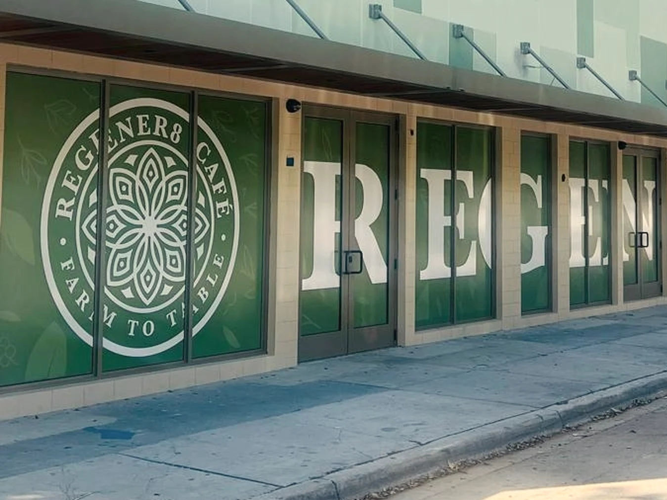 The Regener8 Café frontage on NW 2nd Ave in Wynwood, with the café logo and name on the windows